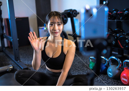 動画配信でフォロワーに手を振る20代女性　ジムで運動するかっこいい女性　ライブ配信　ライバー 130263937