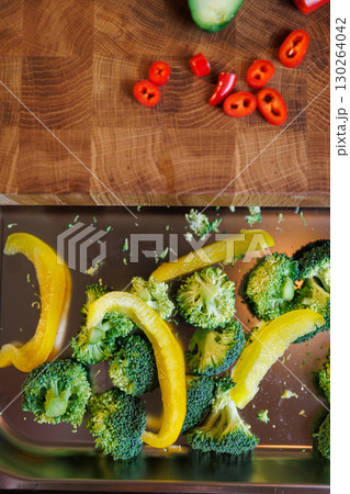 Fresh broccoli and yellow pepper slices on a metal tray, ready for cooking Fresh broccoli and yellow pepper slices on a metal tray, ready for cooking 130264042