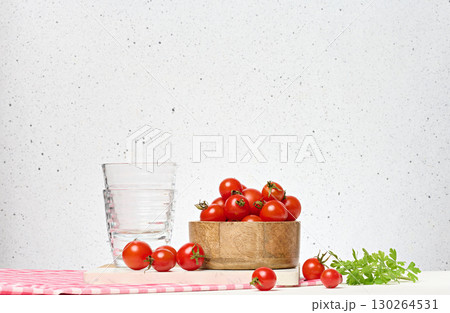 Wooden bowl with red ripe cherry tomatoes and empty glasses on white background Wooden bowl with red ripe cherry tomatoes and empty glasses on white background 130264531