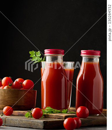 Full glass bottle with tomato juice on dark background Full glass bottle with tomato juice on dark background 130264552