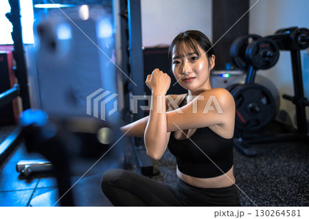 ジムで筋トレ動画配信をする20代女性　ストレッチ運動をするかっこいい女性　ライブ配信　ライバー　 130264581