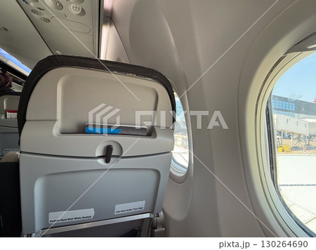 Passenger airplane seat with window view. Air travel, modern transport and tourism lifestyle. 130264690