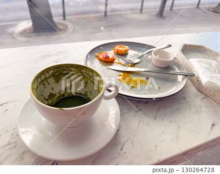 Messy empty plate with food leftovers and coffee cup on marble table. Everyday breakfast moments, lifestyle and dirty table 130264728