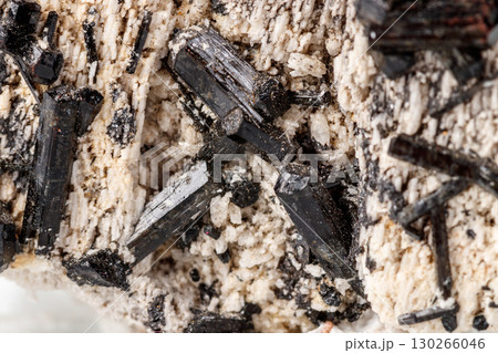 Macro mineral stone Schorl, Black Tourmaline on the feldspar on a white background 130266046
