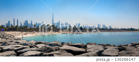 Panoramic view of popular La Mer beach in Dubai, UAE. Coastline with azure sea and high rises in background, United Arab Emirates. High quality photo 130266147