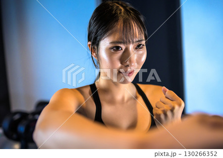 ジムでボクササイズ運動するかっこいい女性　右の拳で殴る　パンチ 130266352