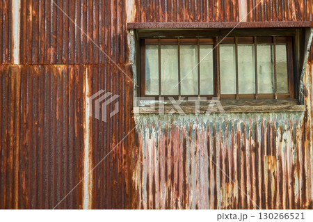 ペンキが剥がれて茶色く錆びた古いトタン板のクローズアップ・金属素材の背景 130266521