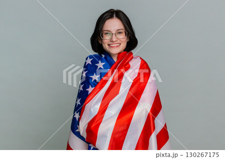 Young woman joyfully waving American USA flag with smile expressing patriotism support pride emotion Young woman joyfully waving American USA flag with smile expressing patriotism support pride emotion 130267175
