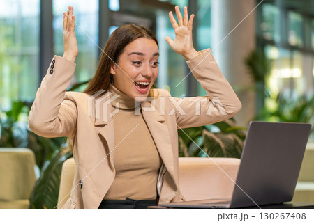 Happy business woman using laptop celebrating success victory, winning, play online game, good news 130267408