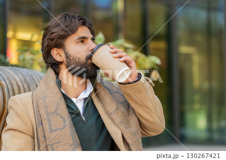 Happy Indian business man tourist enjoying morning coffee hot drink walking on city downtown street Happy Indian business man tourist enjoying morning coffee hot drink walking on city downtown street 130267421