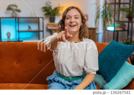 Young woman laughing out loud after hearing ridiculous funny joke sitting on sofa couch at home Young woman laughing out loud after hearing ridiculous funny joke sitting on sofa couch at home 130267581
