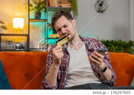 Man use smartphone credit card trying to make payment through internet feels angry due lack of money Man use smartphone credit card trying to make payment through internet feels angry due lack of money 130267605