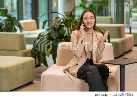 Happy surprised business woman in pleasant conversation phone call good news enjoying talking gossip 130267652