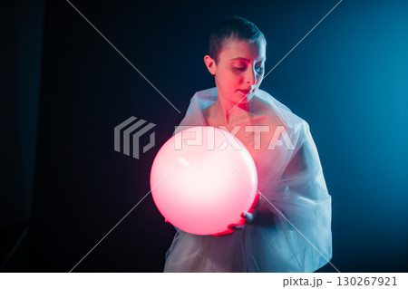 A Pink Light Ball In The Hand Of A Short Haired Woman  130267921