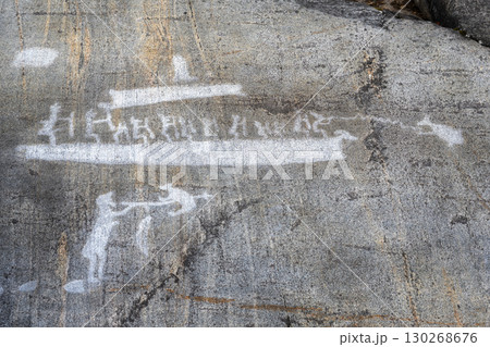 Ancient rock carvings depicting boats and human, primitive drawings on stone surface in Zalavruga, Karelia, Russia. Ancient rock carvings depicting boats and human, primitive drawings on stone surface in Zalavruga, Karelia, Russia. 130268676