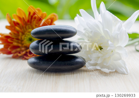 Dual flowers white and yellow beside stacked stones simple calm look with customizable space for text Dual flowers white and yellow beside stacked stones simple calm look with customizable space for text 130269933