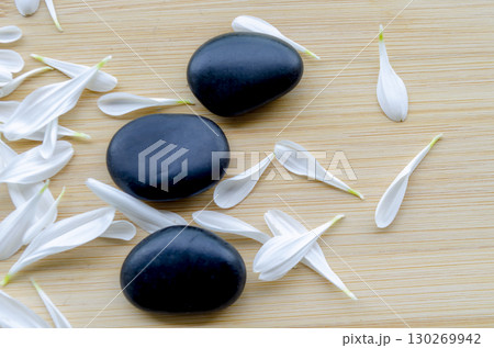 Close up view of fresh white flower next to stacked black stones natural balance with customizable space for text Close up view of fresh white flower next to stacked black stones natural balance with customizable space for text 130269942