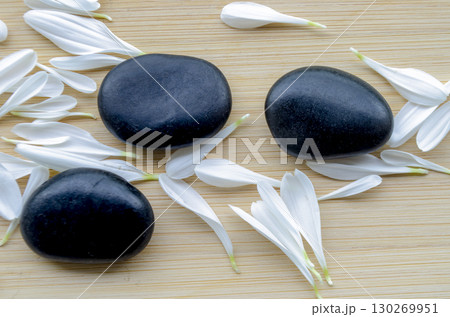 Paired stones resting on large green leaf over neutral wooden surface with customizable space for text. Paired stones resting on large green leaf over neutral wooden surface with customizable space for text. 130269951