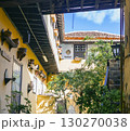 A stylish vintage interior of a house courtyard with yellow walls and small tropical garden in the middle. 130270038