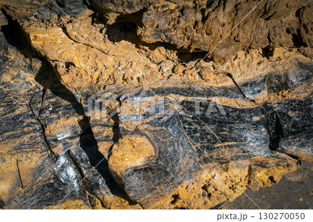 Lava formations, stones, black basalt in the rocks closeup on a volcano terrain. 130270050