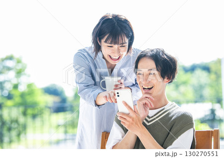 スマホで検索をする夫婦 130270551