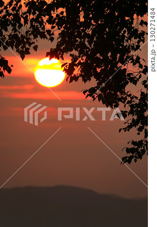 真っ赤に染まった空と沈みゆく太陽のイメージ風景 130271484