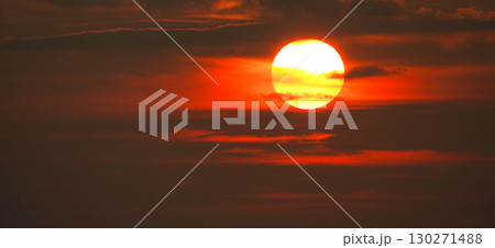 真っ赤に染まった空と沈みゆく太陽のイメージ風景 130271488