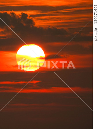真っ赤に染まった空と沈みゆく太陽のイメージ風景 130271491