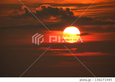 真っ赤に染まった空と沈みゆく太陽のイメージ風景 130271495