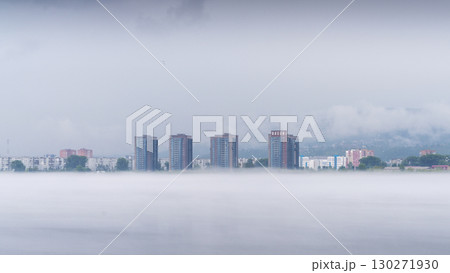 In a tranquil morning setting, fog blankets the residential neighborhood along the Yenisei River in Krasnoyarsk. 130271930