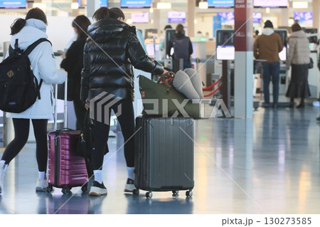 スーツケースを引く旅行客　羽田空港の出発ロビー　旅行客 130273585