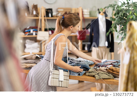 Young woman choosing jeans in clothing store 130273772
