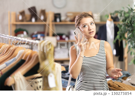Woman making a phone call in a store Woman making a phone call in a store 130273854