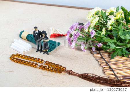 お墓参り用の持ち物と喪服姿の小さな人形 130273927