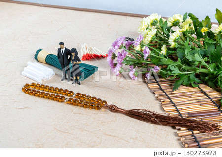 お墓参り用の持ち物と喪服姿の小さな人形 130273928