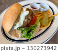 お皿に乗ったハンバーガーとフライドポテトとピクルス 130273942