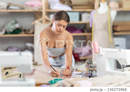 Young fashion designer drawing patterns on paper 130273968