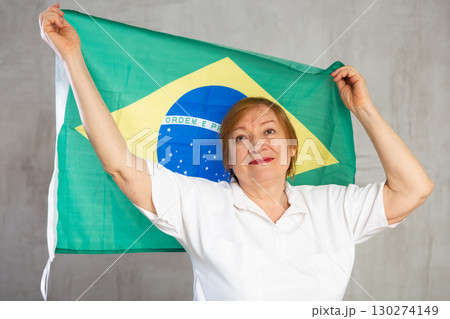 Cheerful senior woman standing confidently with brazilian flag Cheerful senior woman standing confidently with brazilian flag 130274149