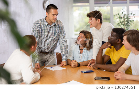 Team leader giving instructions to group of men during work meeting Team leader giving instructions to group of men during work meeting 130274351