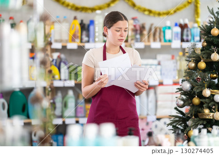 Anxious woman seller with checklist in decorated store 130274405