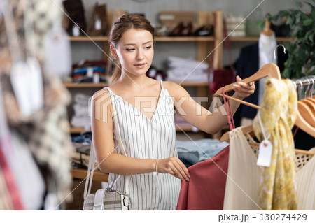 Young woman choosing dress in clothing store Young woman choosing dress in clothing store 130274429