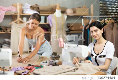 team of dressmakers sews clothes for a customer in a workshop 130274484