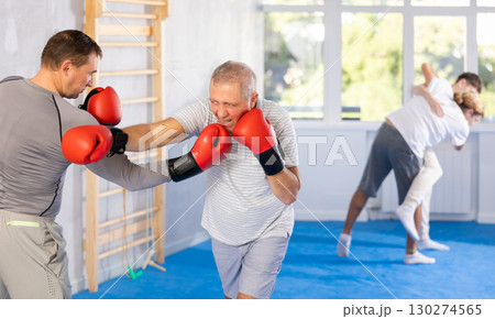 Men in boxing gloves punch deliver blow each other during training sparring session. Men in boxing gloves punch deliver blow each other during training sparring session. 130274565