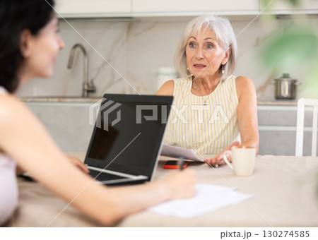 Mature woman meeting financial advisor for investment at home Mature woman meeting financial advisor for investment at home 130274585