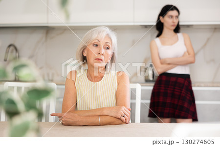 Young woman quarrels with elderly woman in kitchen 130274605