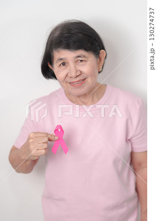 Elderly woman with pink Ribbon for Pink October Breast Cancer Awareness month, May Women Health, February World cancer day, support people life and illness. National cancer survivors month 130274737