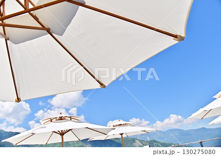 白いパラソルの間に垣間見る夏の北アルプス 白いパラソルの間に垣間見る夏の北アルプス 130275080