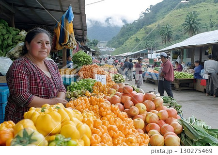 Indigenous woman selling vibrant produce at a bustling Andean ma 130275469