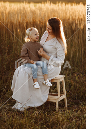 Mother and Daughter Smiling in Wheat Field at Sunset Mother and Daughter Smiling in Wheat Field at Sunset 130275768