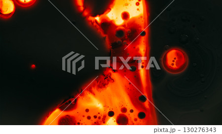Paint droplet. Spill ink texture. Defocused dark orange red glowing neon water liquid oil bubble flowing fluid on black abstract art light background. 130276343